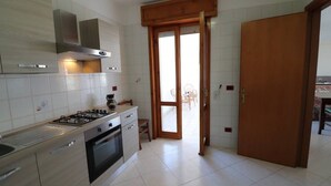A modern kitchen with a gas stove, oven, and stainless steel cabinets. - Wonderful  villa for 8 guests with A/C, WIFI, TV and balcony (Otranto)