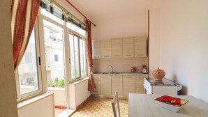 Una cocina pequeña con ventana, un lavamanos y una mesa con un cuenco.