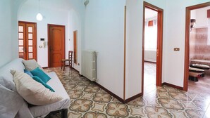 Un salón amplio con sofá, suelo de baldosas estampadas y radiador.