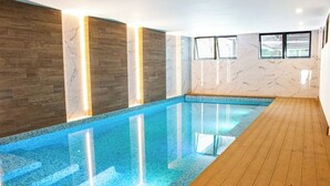 An indoor swimming pool with wooden flooring and marble walls. - *Comfortable apartment* minutes away from cayala (Ciudad de Guatemala)