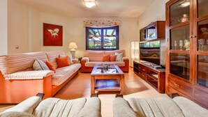 A living room with striped sofas, a coffee table, a TV, and a cabinet. - Rental in Calpe REAL SITIO (Calpe)