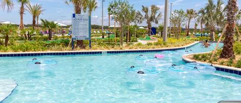 A pool with clear blue water, surrounded by palm trees and a sign indicating no diving.