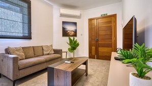 Ein modernes Interieur mit einer Couch, einem Couchtisch, Topfpflanzen und einer Holztür.