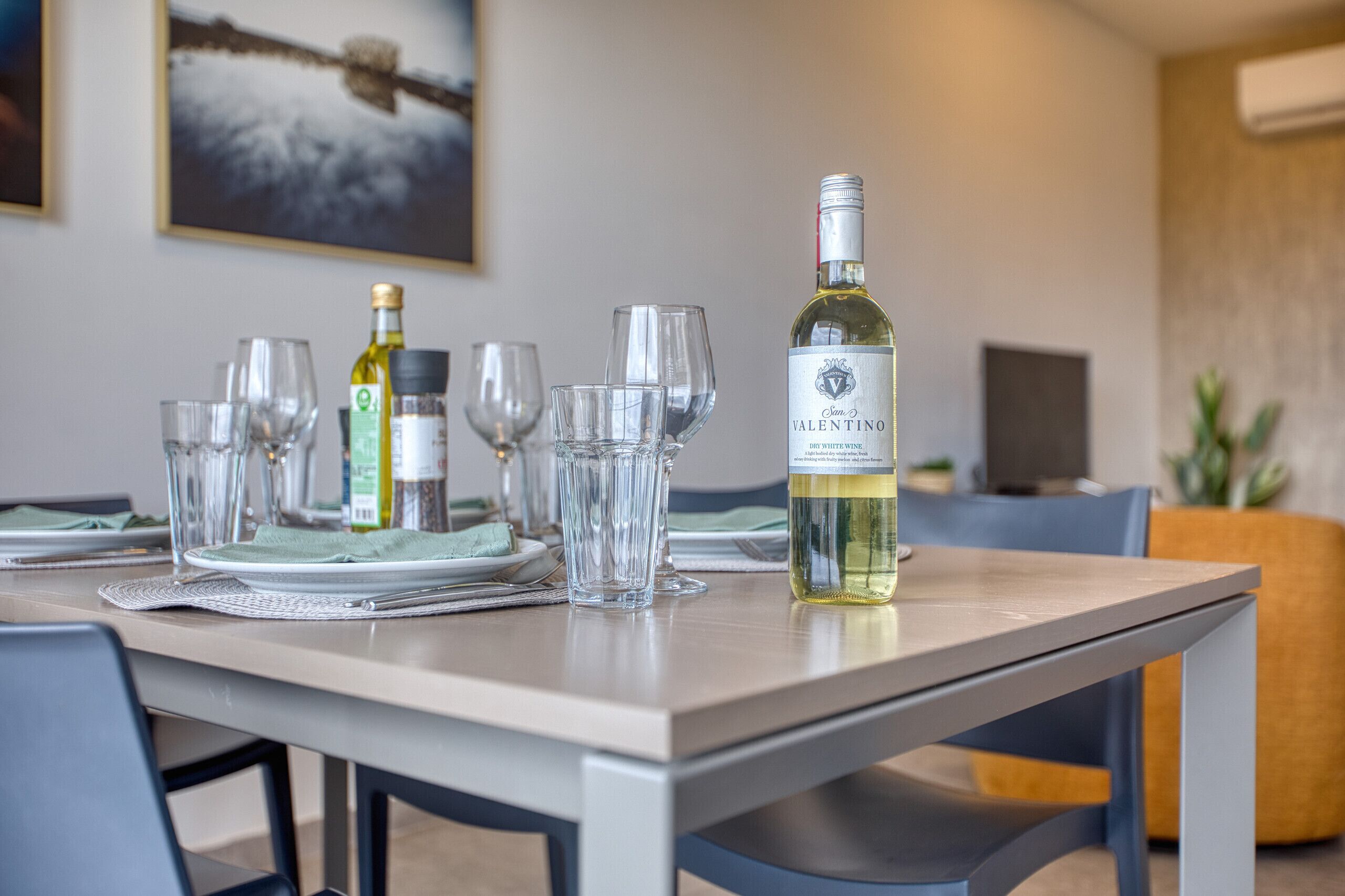 Spisebord med hvidvin, glas og en bordskål.