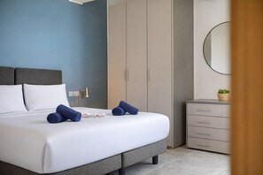 A modern bedroom with a bed, a bedside lamp, a wardrobe, and a dresser. - Modern 2 bedroom apartment, Valley Views KARP1-4 (San Gwann)