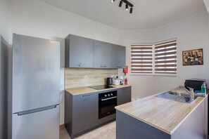 A modern kitchen with a built-in oven, a sink, and a refrigerator. - Central and modern Apartment, Valley Views KARP1-6 (San Gwann)