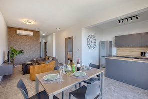 A modern living space with a dining area, kitchen, and seating area. - Central and modern Apartment, Valley Views KARP1-6 (San Gwann)