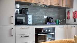 Una cucina compatta con forno a microonde, tostapane, bollitore e fornello.