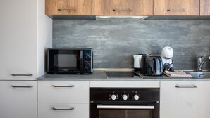 Eine Küche mit Holzschränken, einer Mikrowelle, einem Toaster und einem Backofen.