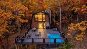 Eine Hütte mit Pool, umgeben von Herbstlaub.