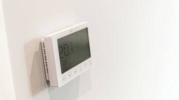Termostato digital montado en una pared blanca.