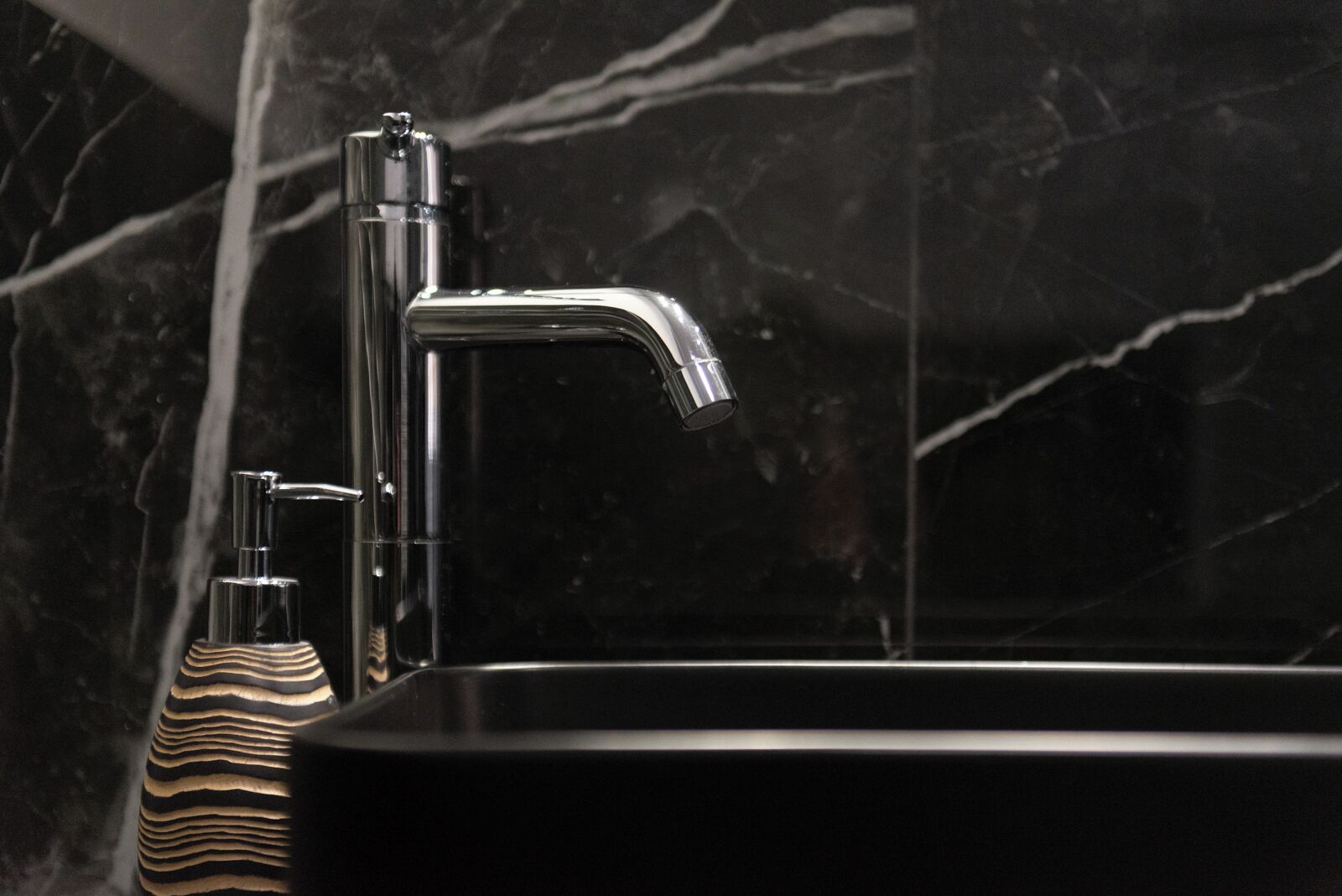 Un baño moderno con un grifo cromado elegante y un lavamanos rectangular.