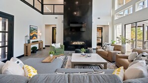 Un amplio salón con chimenea, sofás y una mesa de centro.