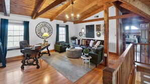 A spacious living room with wooden beams, a large clock, and a cozy seating area. - Pine Mountain Lodge Game Room & Wrap-around Porch 5 Bedroom Cabin (Connellys Springs)