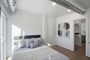 A bedroom with a bed, a radiator, and artwork on the wall. - Modern 2br Near Downtown Okc 2 Bedroom Home (Oklahoma City)