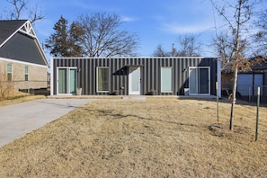 A modern single-story building with a flat roof, large windows, and a small front porch. - Modern 2br Near Downtown Okc 2 Bedroom Home (Oklahoma City)