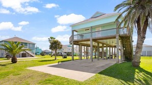 A beachfront property with a covered patio, a pool, and a two-story building. - Buho Vista 2 Bedroom Home (Port Bolivar)