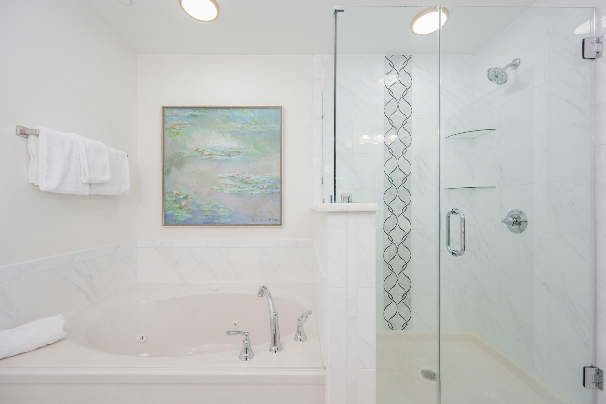 Une salle de bain moderne avec une grande baignoire, une douche à l’italienne et un tableau au mur.