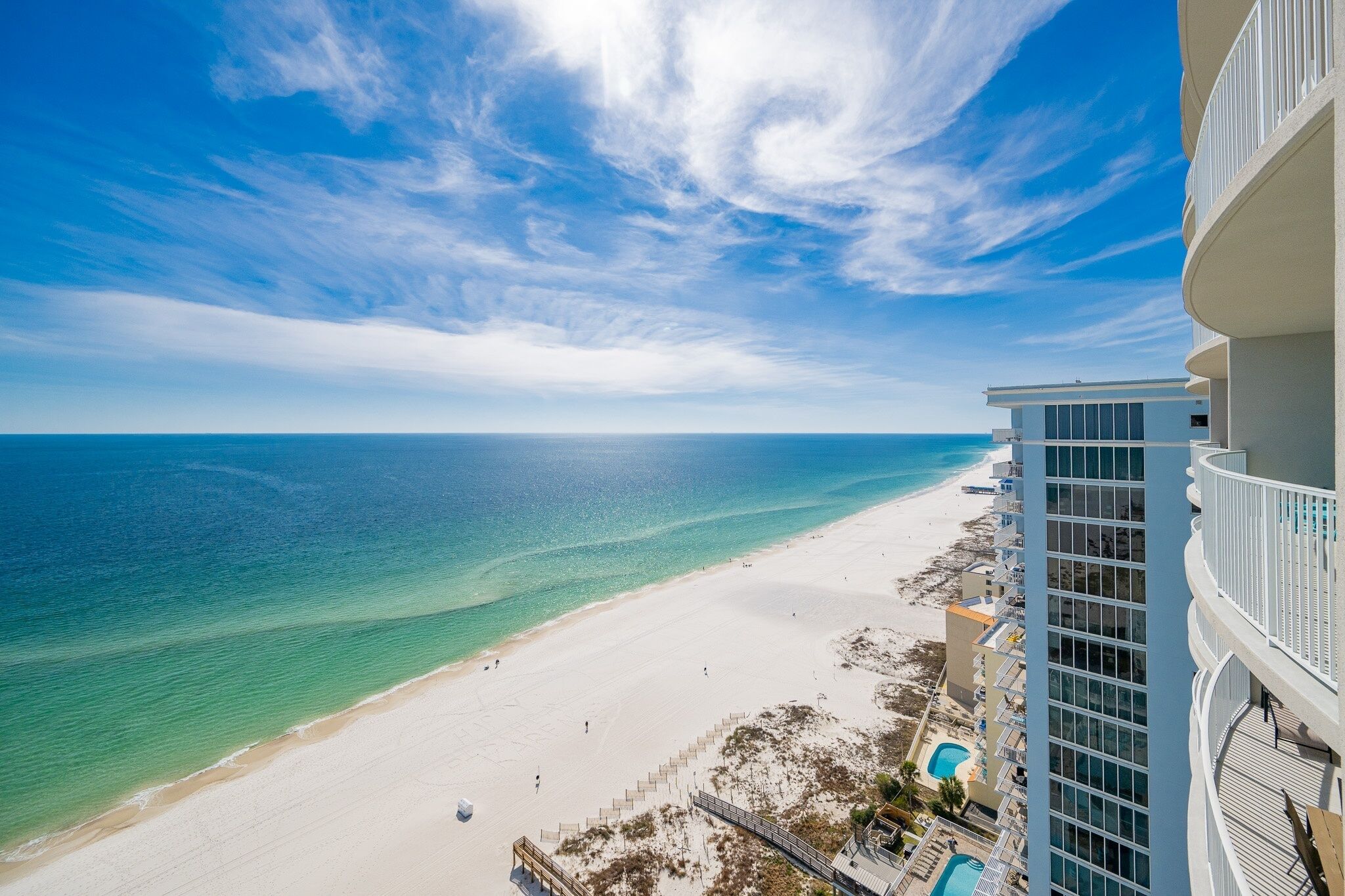 A beachfront hotel with a clear view of the ocean and beach.
