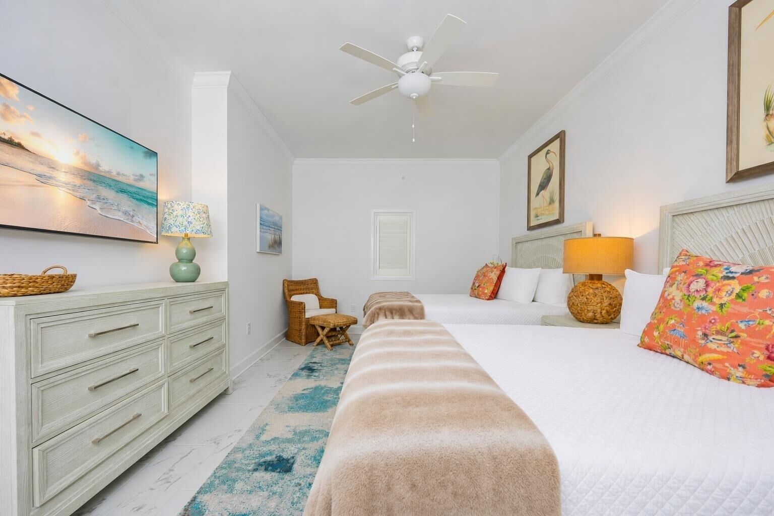 Une chambre à coucher comprenant un lit, une commode, une chaise, une table de chevet et un ventilateur de plafond.