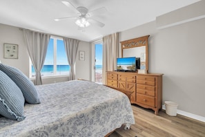 A bedroom with a bed, a wooden dresser, a ceiling fan, a television, and a view of the ocean. - 307 Island Princess ~ 3 Bedroom 3 Bath Sleeps 8 ~ Gulf Front FREE BEACH SVC (Fort Walton Beach)