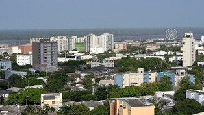 A coastal cityscape with high-rise buildings, a Ferris wheel, and a clear view of the sea. - Apartaestudio Shanty Tipo 1 (Barranquilla)