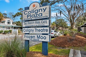 Schild für Coligny Plaza mit aufgeführten Geschäften, darunter das Café Frosty Frog, das Coligny Theatre und Frozen Moo Eis.