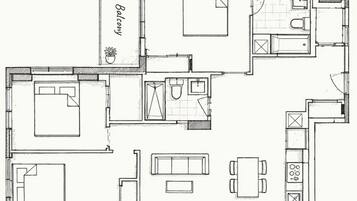 Een plattegrond van een hotelkamer met een balkon, een keuken, een eetgedeelte en een zithoek.