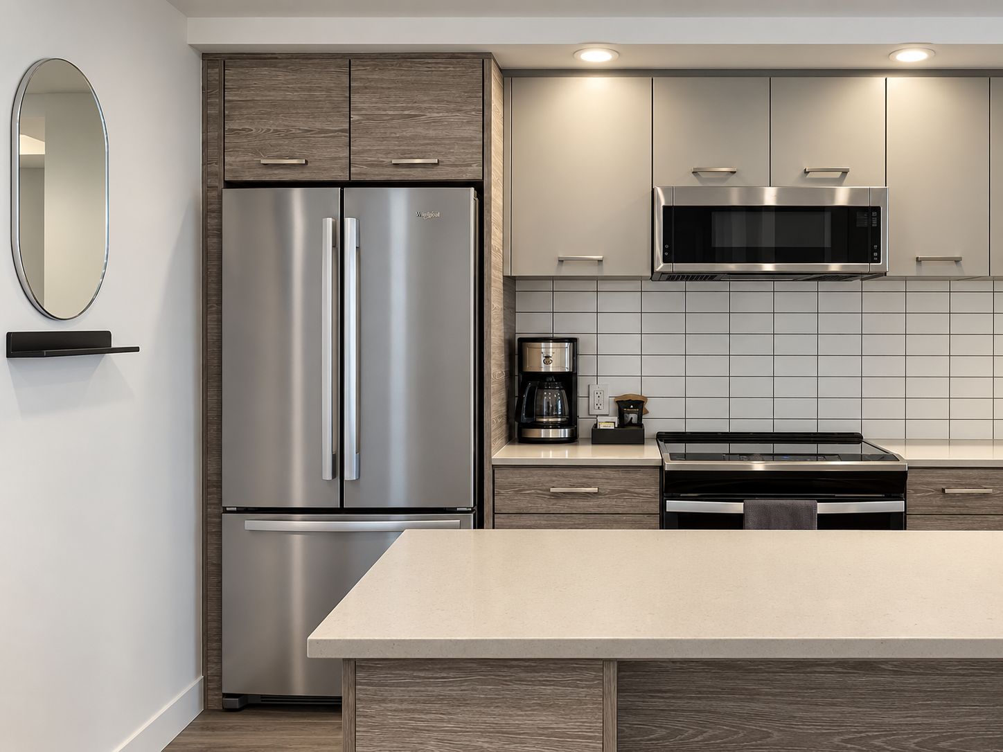 A modern kitchen with a stainless steel refrigerator, a microwave, and a coffee maker.