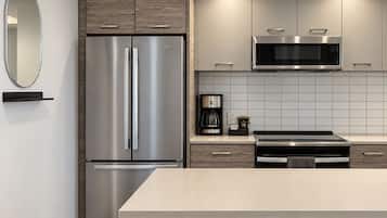 A modern kitchen with a stainless steel refrigerator, a microwave, and a coffee maker.