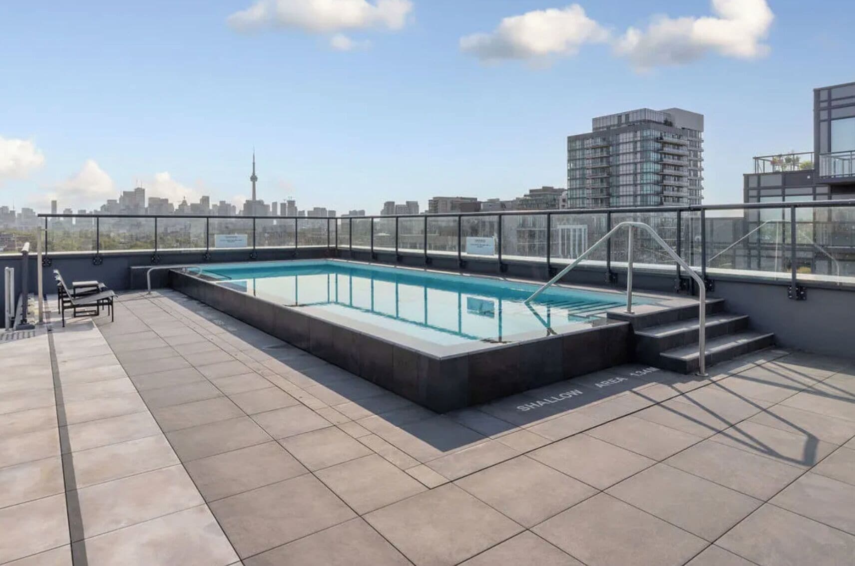 Una piscina al aire libre de temporada, tumbonas