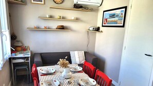 Ein Essbereich mit gestreifter Tischdecke, roten Stühlen und einer zentral platzierten Vase.