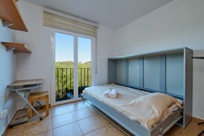 A bedroom with a bed, a small table, a bench, and a sliding door to a balcony. - 1Mel01 - House with private pool for 7 people near one of the most beautiful beaches in Begur (Begur)