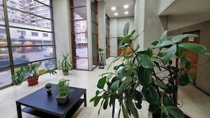 Un intérieur moderne avec de grandes fenêtres, des plantes d’intérieur et une table.