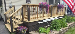 A wooden deck with a staircase leading to a house.