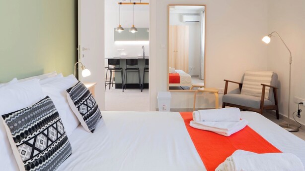 Een hotelkamer met een bed, een bureau, een stoel en een spiegel.