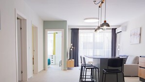 Een moderne keuken met een centraal kookeiland, barstoelen en hanglampen.