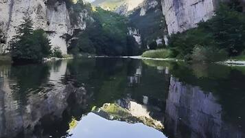 Een rustige rivierkloof met kliffen aan beide zijden en een heldere weerspiegeling in het water.