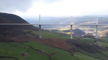 Eine Brücke mit mehreren Kabeln, die ein Tal überspannt.