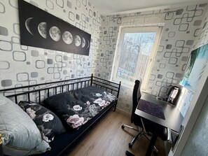 A bedroom with a bed, a desk, and a window. - Apartment 'Sterntaler Melsungen' (Melsungen)
