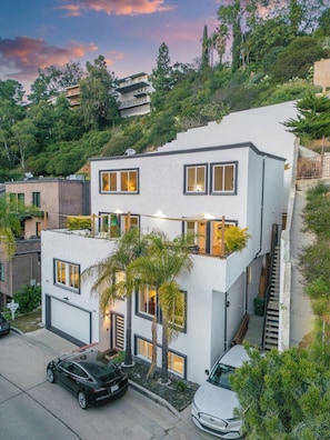 Ein modernes, zweistöckiges Haus mit Garage, Treppe und Auffahrt.