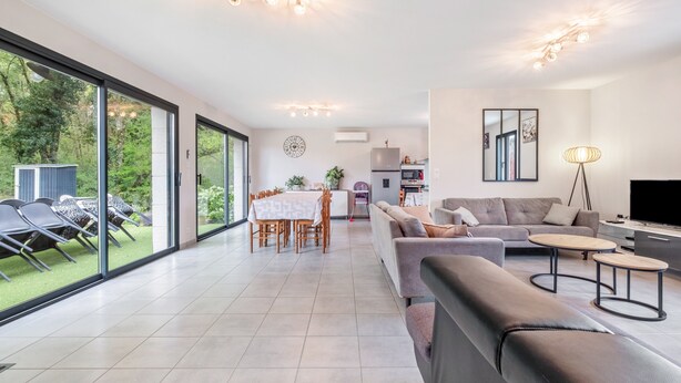 A spacious living area with a sofa, coffee table, and dining table. - Holiday Home “Gite Chez Léontine” with Private Terrace, Wi-Fi and Air Conditioning (Lacave)