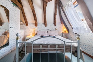 A bedroom with a bed, wooden beams, a window with curtains, and patterned wallpaper. - Holiday Home “La Vallée de l’Ouysse 5”: Mountain View, Wi-Fi, Air Conditioning (Lacave)
