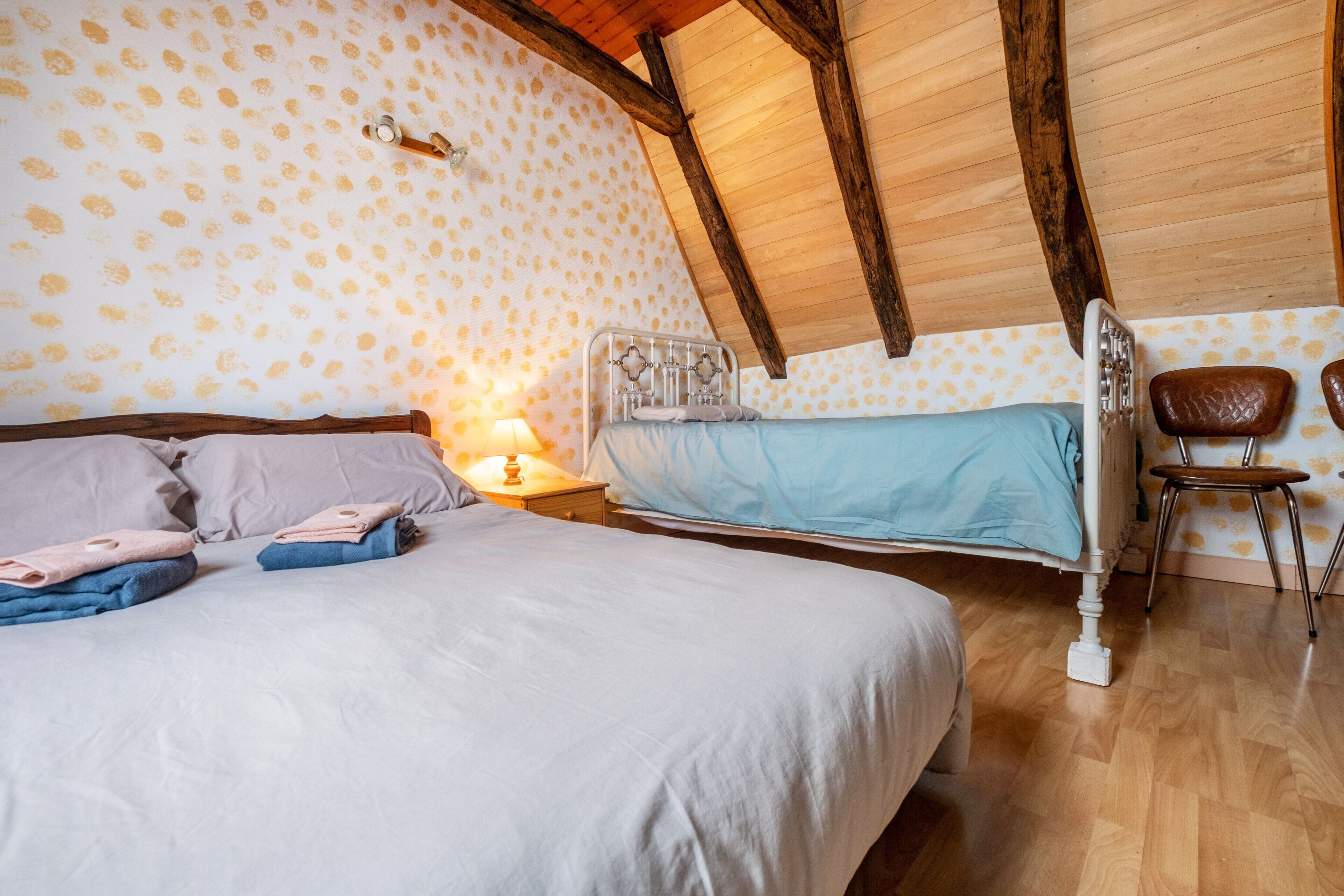 Ein Schlafzimmer mit einem Bett, einem Sessel und einem Nachttisch.
