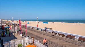 A boardwalk with beach views, benches, and a pier extending into the water. - Columbus Villa 107 - 3 bedroom on the boardwalk with great beach and ocean views~ (Ocean City)