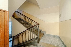Eine Treppe mit aufwendiger Metallreling und Steinstufen.