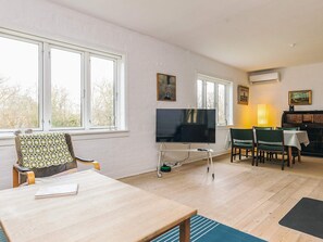 A living room with a TV, a dining table, and a sofa. - 6 Person Holiday Home in Stege (Stege)