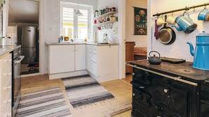 A kitchen with a refrigerator, stove, and various kitchen utensils. - 6 Person Holiday Home in Stege (Stege)