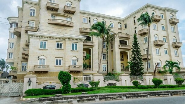A multi-story hotel with balconies, a gated entrance, and well-maintained landscaping. - Clayhall By SRS (Lagos)