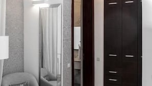 A modern bedroom with a bed, a chair, a mirror, and a wardrobe. - Clayhall By SRS (Lagos)